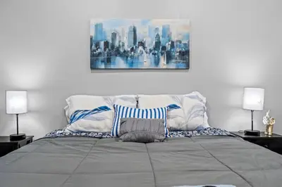 a bedroom with a bed with a painting on the wall at Elegant 1BR Stay Near Zoo & Downtown Philly in Philadelphia