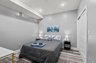 a bedroom with a large bed in a white room at Elegant 1BR Stay Near Zoo & Downtown Philly in Philadelphia