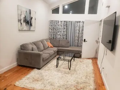 a living room with a couch and a table at Deluxe 3 bedroom in Newark