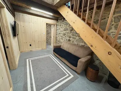 a living room with a couch and a staircase at Spacious Barn House experience! in Hellertown