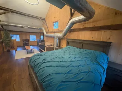 a bedroom with a bed in a room with wooden walls at Spacious Barn House experience! in Hellertown