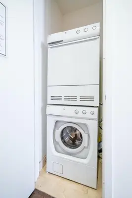 a washer and dryer in a white laundry room at FiDi Studio w Work Setup by Anyplace - 10250 in New York