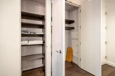 a walk in closet with white walls and shelves at FiDi Studio w Work Setup by Anyplace - 10254 in New York