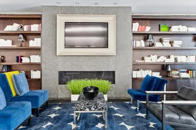 a living room with blue chairs and a tv at FiDi Studio w Work Setup by Anyplace - 10254 in New York
