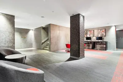 a living room with a couch and a column at FiDi Studio w Work Setup by Anyplace - 10254 in New York