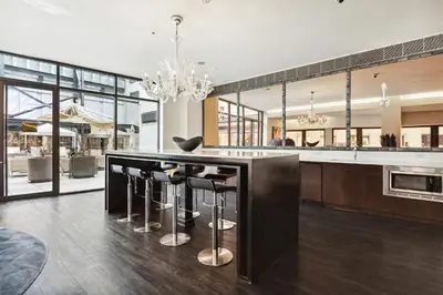 a kitchen with a large island with bar stools at FiDi Studio w Work Setup by Anyplace - 10254 in New York