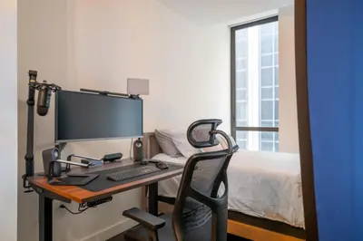 a desk with a computer and a bed in a room at FiDi Studio w Work Setup by Anyplace - 10254 in New York