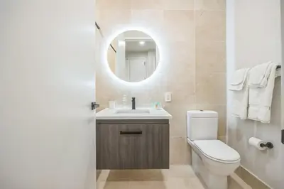 a bathroom with a toilet and a sink and a mirror at FiDi Studio w Work Setup by Anyplace - 11679 in New York