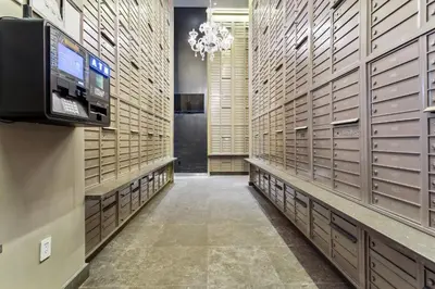 a walk in closet with lockers and a chandelier at FiDi Studio w Work Setup by Anyplace - 11679 in New York