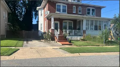 a brick house with a porch and a driveway at Belmont Place in Wilmington