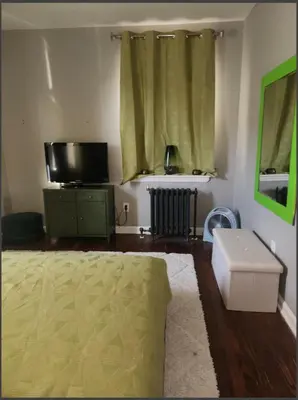 a living room with a bed and a flat screen tv at Belmont Place in Wilmington
