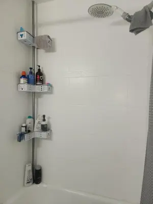 a bathroom with three shelves above a bath tub at Belmont Place in Wilmington