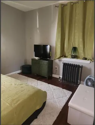 a bedroom with a bed and a flat screen tv at Belmont Place in Wilmington