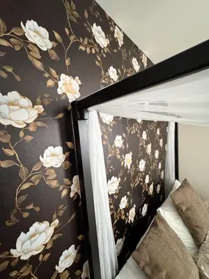 a bedroom with a black and gold floral wallpaper at 30 min from NYC luxury and chic 3 bedroom in Harrison