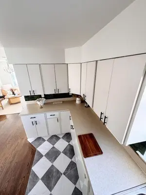 an empty room with white cabinets and a checkered floor at 30 min from NYC luxury and chic 3 bedroom in Harrison