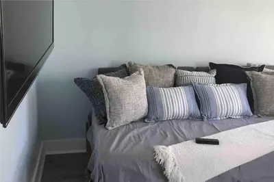 a bed with a bunch of pillows on it at The Executive Penn's Landing - High End Luxury 3BR-Sauna-Gym-Garage-Roof Deck in Philadelphia