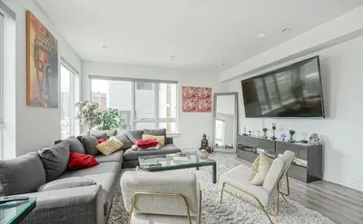 a living room with a couch and a tv at The Executive Penn's Landing - High End Luxury 3BR-Sauna-Gym-Garage-Roof Deck in Philadelphia