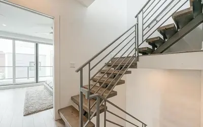 a staircase in a home with white walls at The Executive Penn's Landing - High End Luxury 3BR-Sauna-Gym-Garage-Roof Deck in Philadelphia