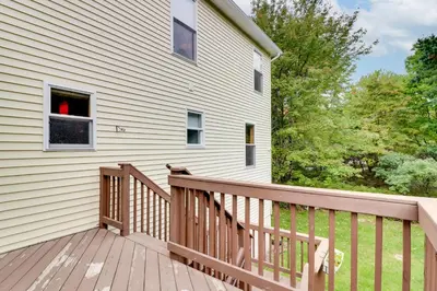 a home with a wooden deck next to a house at Game Room Retreat 5 Mi to Big Boulder Mtn in Blakeslee