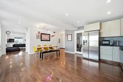 a kitchen and living room with a table and yellow chairs at Beautiful 4th Floor Walk-Up Apartment in Old City in Philadelphia