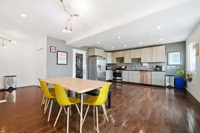 a kitchen and dining room with a wooden table and yellow chairs at Beautiful 4th Floor Walk-Up Apartment in Old City in Philadelphia