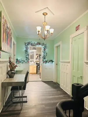 a dining room with green walls and a table and a chandelier at Big Mama's House in Paterson