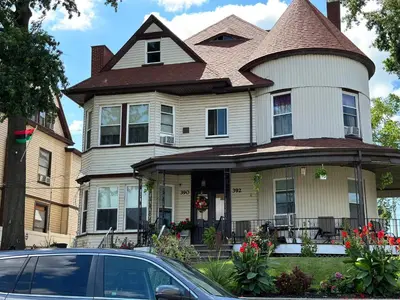 a house with a car parked in front of it at Big Mama's House in Paterson
