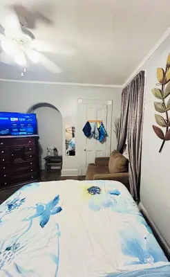 a bedroom with a bed with blue flowers on it at Big Mama's House in Paterson