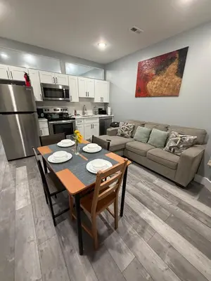 a kitchen and living room with a table and a couch at Beautiful & Peaceful 1-Bedroom Suite in Philadelphia