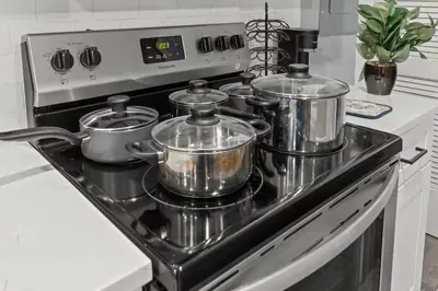 a stove with four pots and pans on it at Beautiful & Peaceful 1-Bedroom Suite in Philadelphia