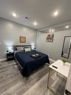 a bedroom with a blue bed and a table at Beautiful & Peaceful 1-Bedroom Suite in Philadelphia