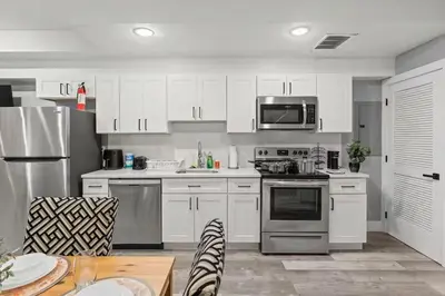 a kitchen with white cabinets and stainless steel appliances at Beautiful & Peaceful 1-Bedroom Suite in Philadelphia