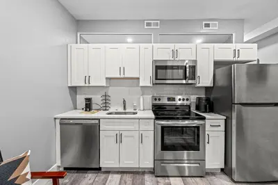 a kitchen with white cabinets and stainless steel appliances at Beautiful & Peaceful 1-Bedroom Suite in Philadelphia