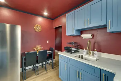a kitchen with blue cabinets and a table with chairs at Colorful and Convenient Darby Apt, 7 Mi to Stadiums! in Darby