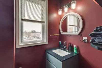 a bathroom with a sink and a mirror at Colorful and Convenient Darby Apt, 7 Mi to Stadiums! in Darby