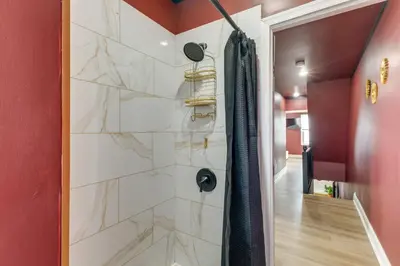 a shower in a bathroom with red walls at Colorful and Convenient Darby Apt, 7 Mi to Stadiums! in Darby