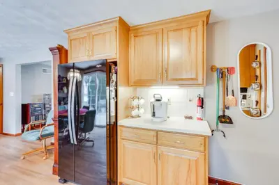 a kitchen with wooden cabinets and a refrigerator at Three Pines Family Retreat Home in Carlisle in Carlisle