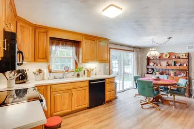 a kitchen with wooden cabinets and a table and chairs at Three Pines Family Retreat Home in Carlisle in Carlisle