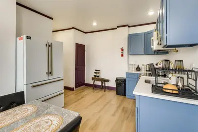 a kitchen with blue cabinets and a white refrigerator at 7 Mi to Philly Stadiums! Charming Apartment in Darby