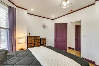 a bedroom with a large bed and a purple door at 7 Mi to Philly Stadiums! Charming Apartment in Darby