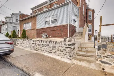 a stone retaining wall in front of a house at 7 Mi to Philly Stadiums! Charming Apartment in Darby