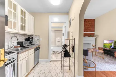 a kitchen with white cabinets and a sink at Brooklyn Heights 2BR Secret Retreat in Brooklyn