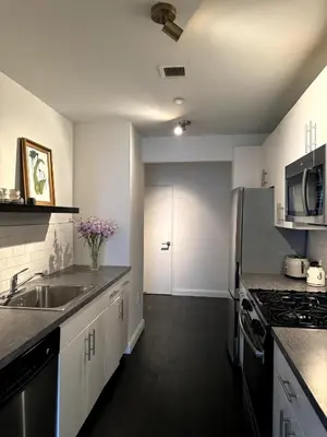 a white kitchen with a sink and a stove at Hudson River - Lincoln Center in New York