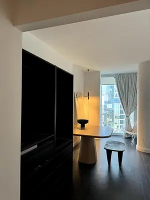 a living room with a table and a large window at Hudson River - Lincoln Center in New York