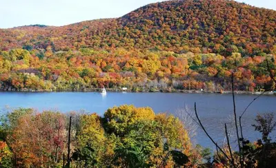 a lake with a boat in the middle of a mountain at Luxury Townhouse Near West Point in Highland Falls