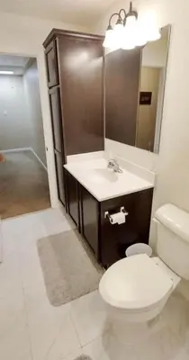 a bathroom with a toilet and a sink and a mirror at Luxury Townhouse Near West Point in Highland Falls