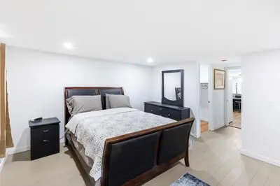 a bedroom with a large bed and a mirror at Orange NJ 2BR Duplex | Walk to Train + 2BA in Orange