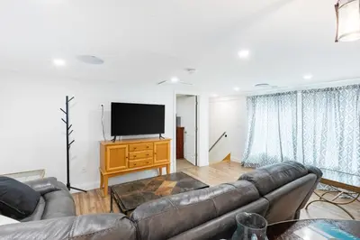 a living room with a couch and a flat screen tv at Orange NJ 2BR Duplex | Walk to Train + 2BA in Orange