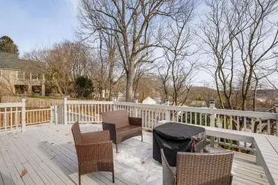 a deck with chairs and a table and a fence at Home with Lake Views and Deck in New Jersey Highlands! in Stanhope