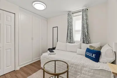 a bedroom with a bed with a chair and a window at 3BR Gem in Graduate Hospital in Philadelphia